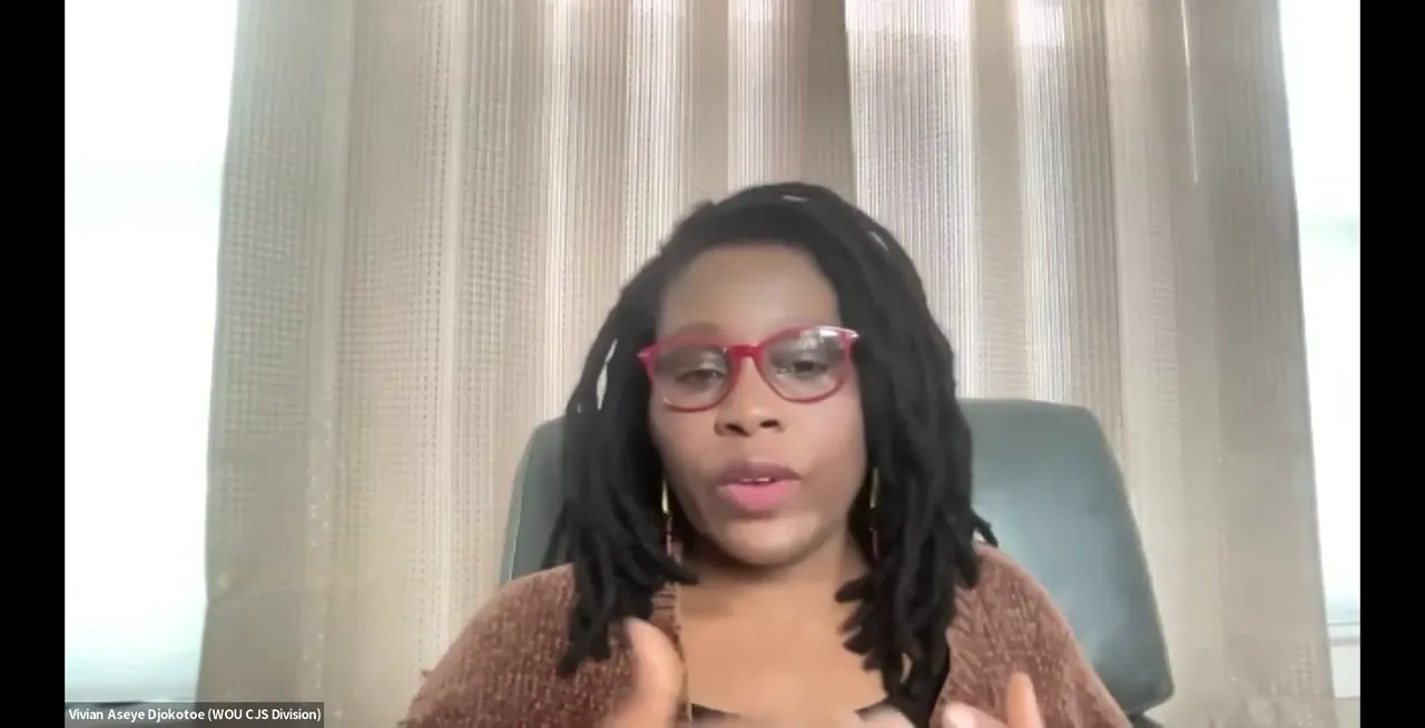 A woman with dreadlocks and glasses is speaking in front of a window with blinds. A name caption at the bottom reads "Ifean Asiya Djikotse (WOU CJS Division)".