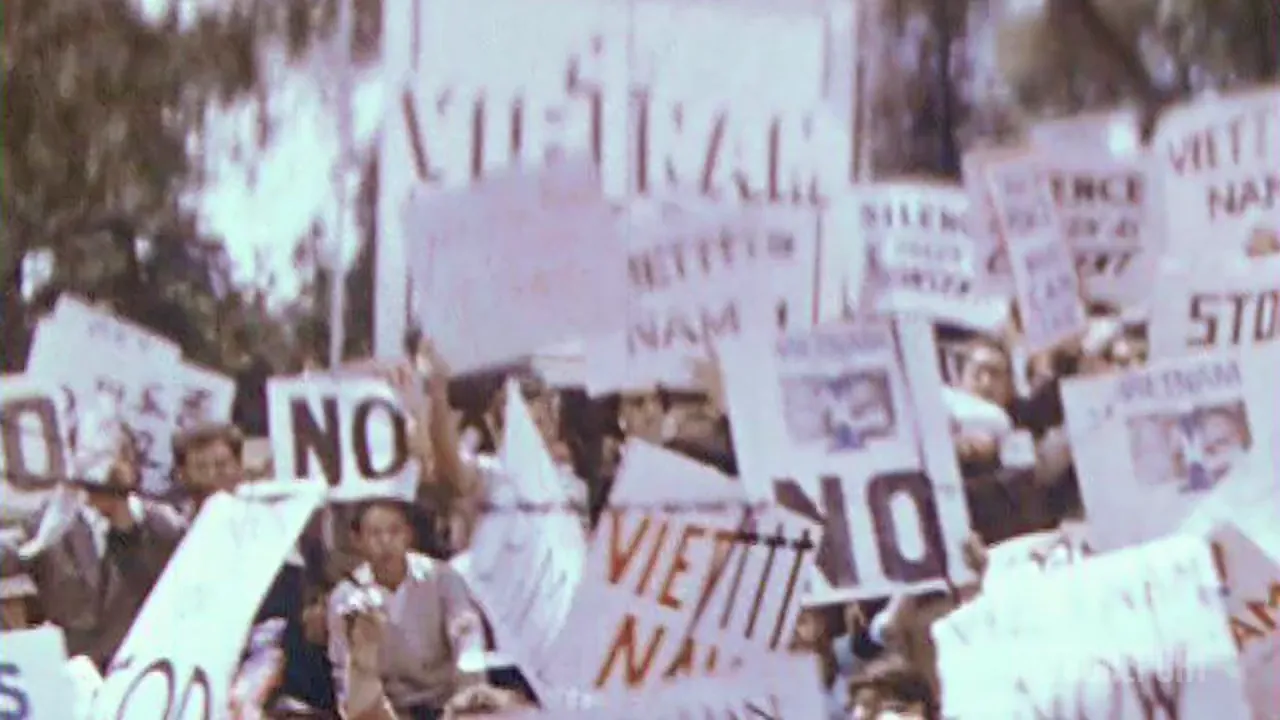 A crowd of people are holding signs that say "NO" and "VIET NAM", protesting.